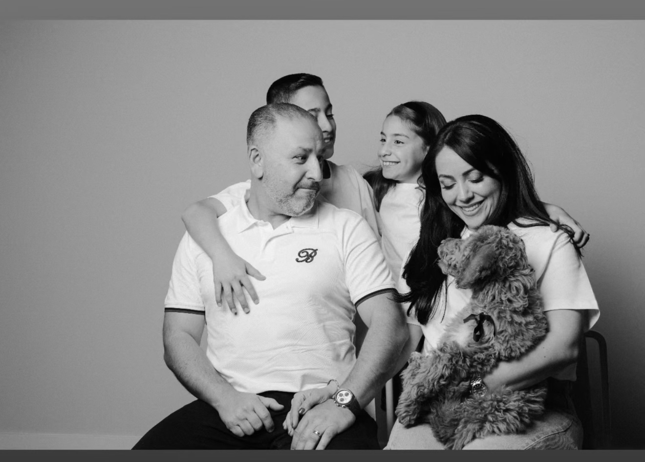 The Kid's Best Doodle family — Armen, his wife, and daughter — at home with their Goldendoodle puppy